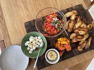 Serving display of bruschetta, crostini, mozzarella, and roasted garlic