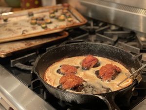 Panko chicken cooking in a cast-iron skillet