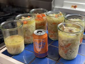 Jars of soup staring down a beer can
