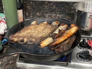 Short ribs searing in a cast iron skillet