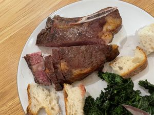 Ribeye on a plate with bread and kale