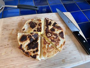 Quesadillas arranged like a pizza on a cutting board