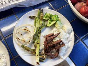 Bulgogi on rice with onions and cucumber, served on a plate