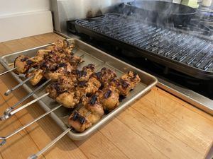 Chicken resting in front of a hot grill pan