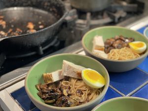 Turkey ramen in front of a pan of sauteed mushrooms