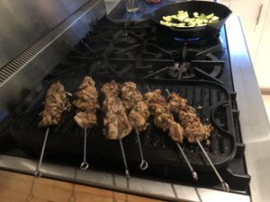 Kebabs on a grill pan, zuchinni cooking in the background