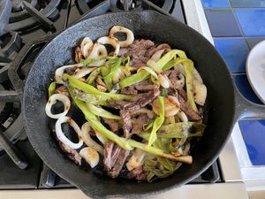 meat & onions heating in a cast-iron skillet