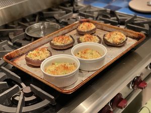Stuffed mushrooms and ramekins on a sheet pan