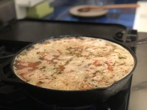 A cast iron skillet cooking, filled to the brim