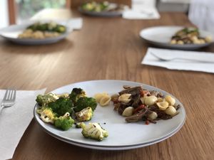 Pulled pork with pasta and broccoli on plates